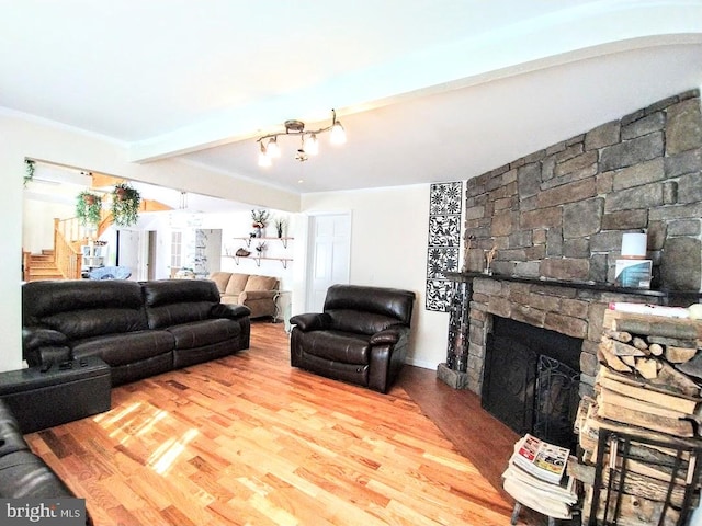 living room featuring a fireplace, light hardwood / wood-style floors, and beam ceiling