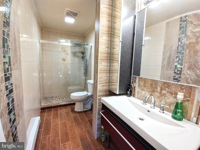 bathroom featuring crown molding, toilet, a baseboard radiator, a shower with shower door, and vanity