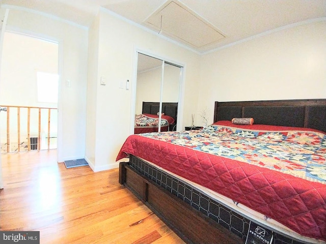 bedroom with crown molding, a closet, and light wood-type flooring