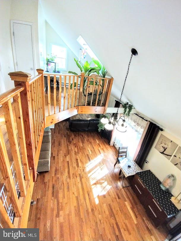 living room with vaulted ceiling with skylight and hardwood / wood-style flooring