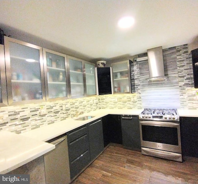 kitchen with backsplash, dark hardwood / wood-style flooring, sink, wall chimney exhaust hood, and appliances with stainless steel finishes