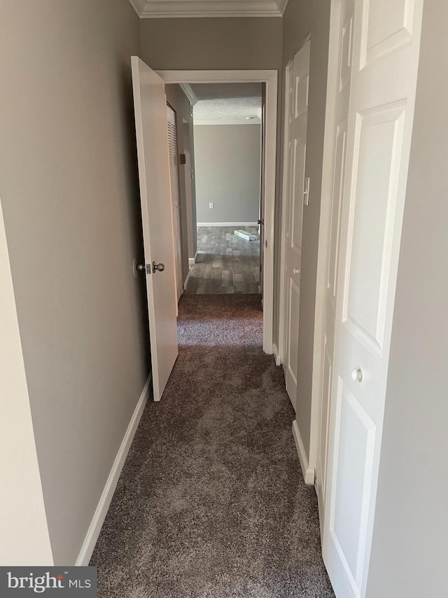 corridor with dark carpet and ornamental molding