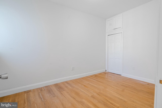 unfurnished room featuring baseboards and light wood finished floors