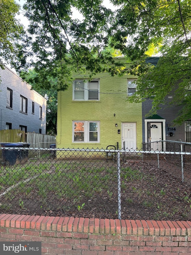 view of front of property featuring fence and brick siding