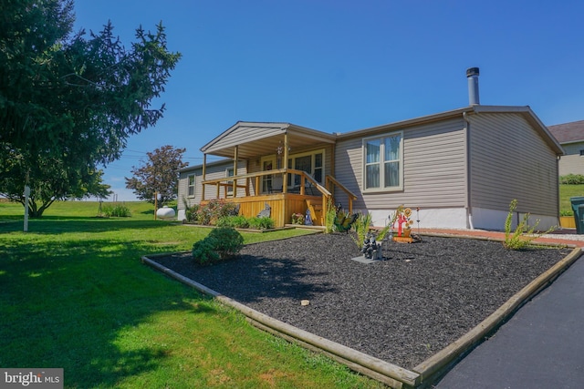 back of property with a yard and covered porch