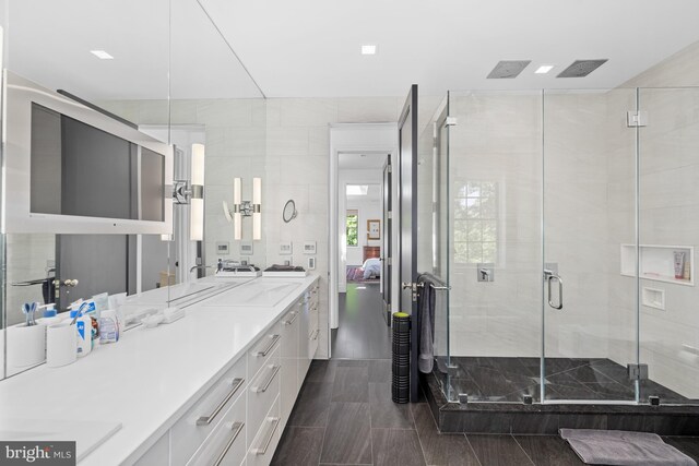 bathroom featuring tile walls, a shower with door, and vanity