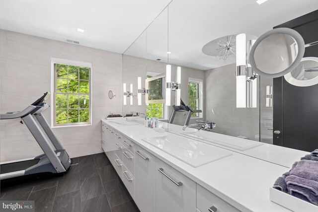 kitchen with tile walls, light stone counters, decorative light fixtures, and white cabinets