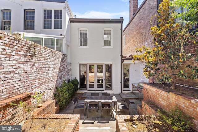 rear view of house featuring a patio and brick siding