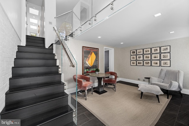 staircase with tile patterned floors, baseboards, and a high ceiling