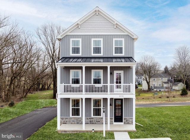 view of front of house with a balcony and a front lawn