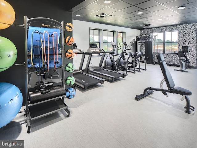 workout area with carpet flooring, a drop ceiling, and a healthy amount of sunlight