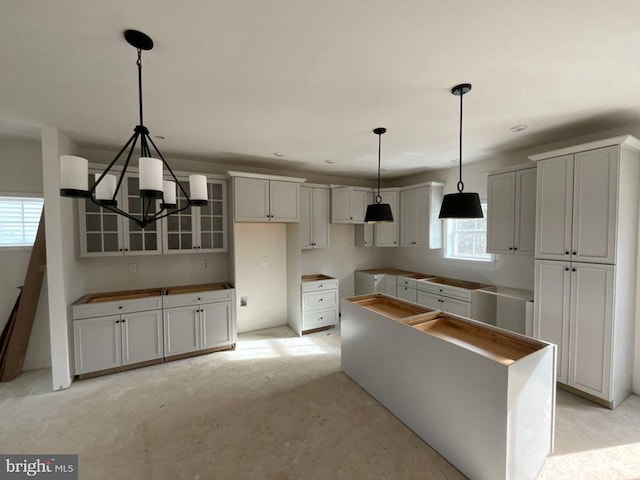 kitchen with white cabinets, decorative light fixtures, and a kitchen island