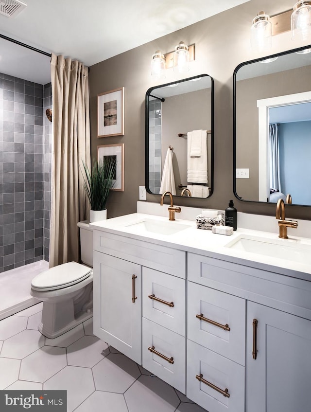 bathroom featuring toilet, vanity, tile patterned floors, and walk in shower