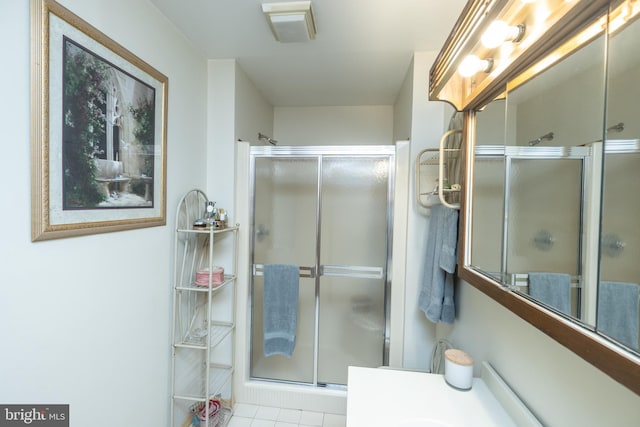 bathroom featuring vanity, a shower with shower door, and tile patterned floors