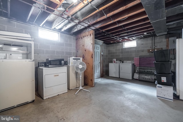 basement featuring white fridge and washer and dryer