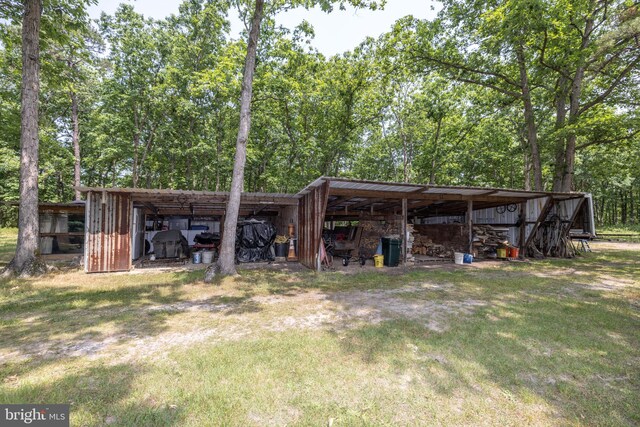 back of house with a yard and an outbuilding