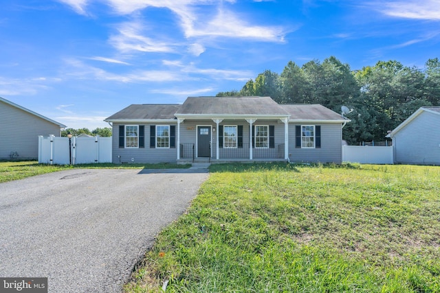 ranch-style house featuring covered porch and a front yard