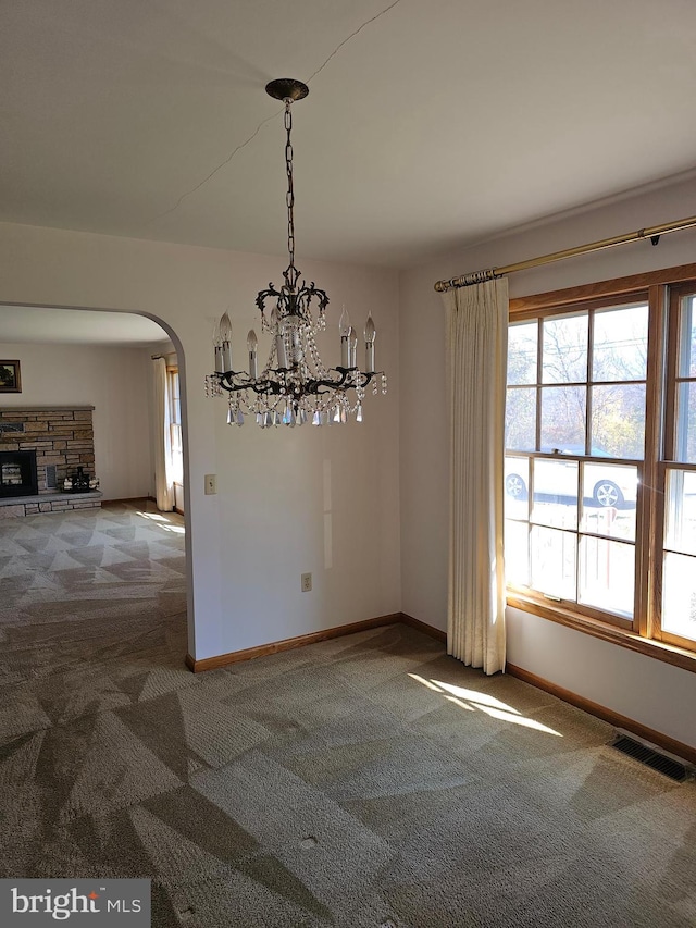 unfurnished dining area featuring carpet floors and an inviting chandelier