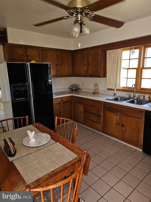 kitchen featuring light tile patterned flooring, black appliances, sink, and ceiling fan