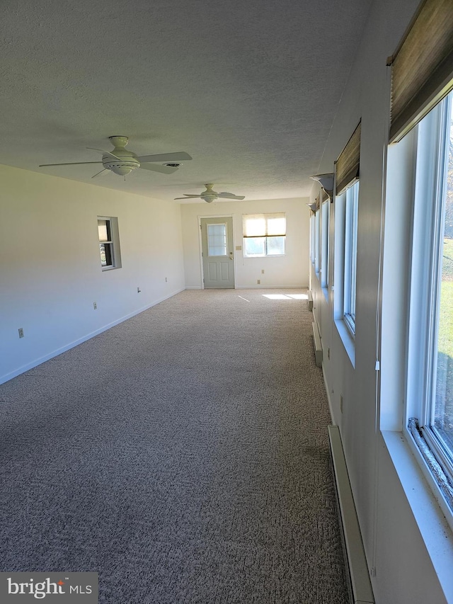 carpeted empty room with ceiling fan and a textured ceiling