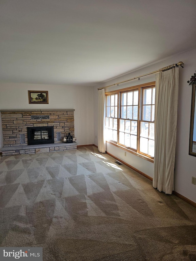 unfurnished living room with light carpet and a stone fireplace