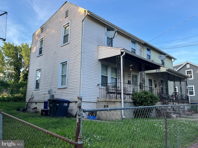 view of home's exterior featuring a porch and a yard