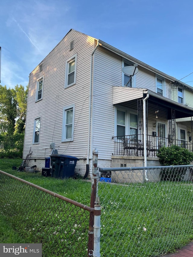 view of side of home featuring a lawn and covered porch