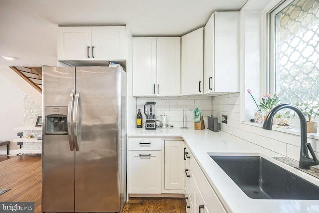 kitchen featuring stainless steel refrigerator with ice dispenser, dark hardwood / wood-style floors, sink, and white cabinetry