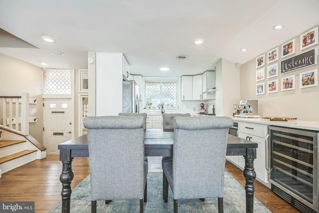 dining area with beverage cooler and dark hardwood / wood-style floors