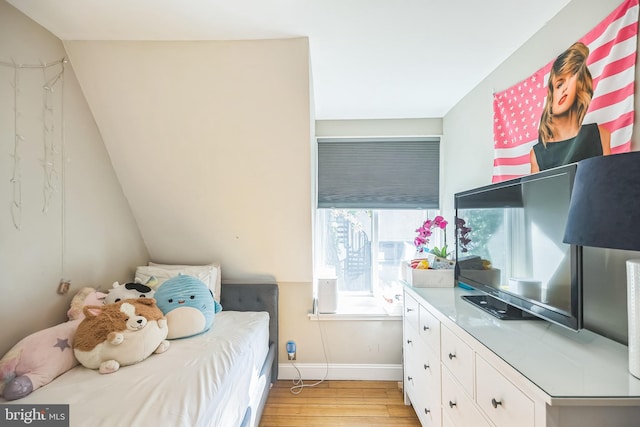 bedroom featuring light wood-type flooring and lofted ceiling