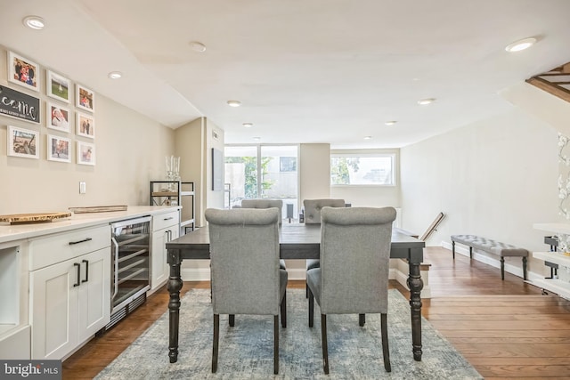 dining area featuring indoor bar, wine cooler, and dark wood-type flooring