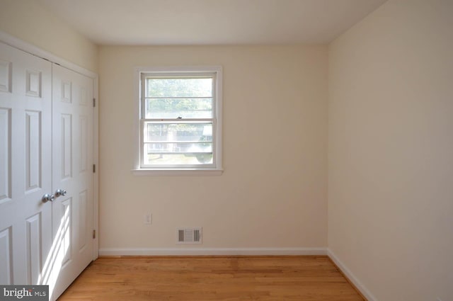 unfurnished bedroom with a closet and light hardwood / wood-style floors