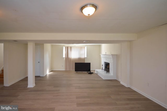 unfurnished living room with hardwood / wood-style floors and a brick fireplace