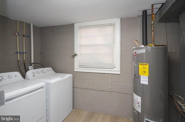 washroom featuring washer and dryer, light hardwood / wood-style flooring, and electric water heater