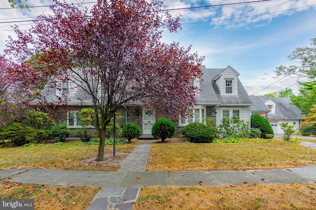 cape cod-style house with a front yard