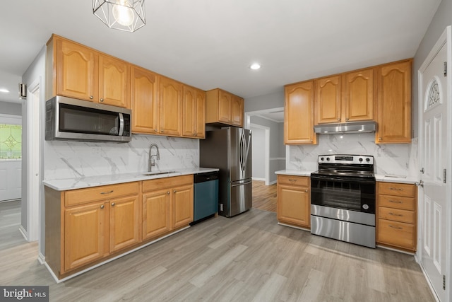 kitchen featuring sink, stainless steel appliances, light hardwood / wood-style floors, and tasteful backsplash