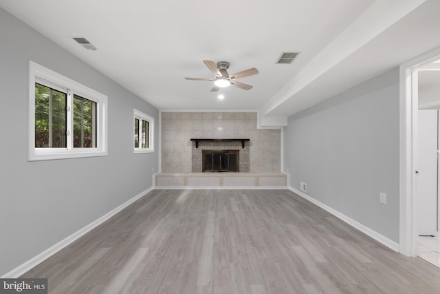 unfurnished living room featuring light wood-type flooring, a fireplace, and ceiling fan