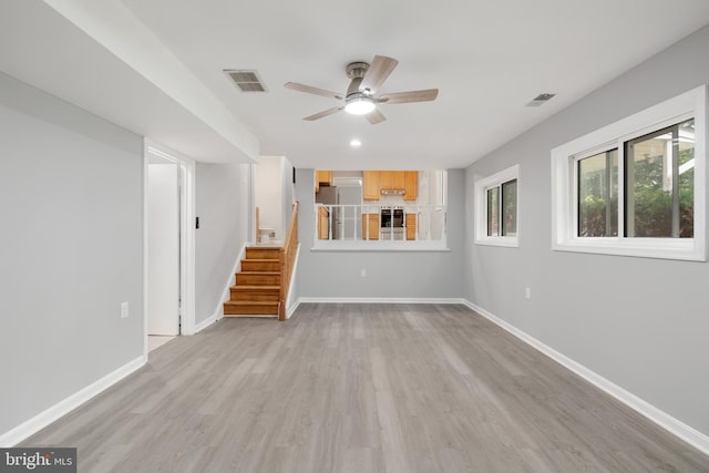 unfurnished living room with ceiling fan and light wood-type flooring