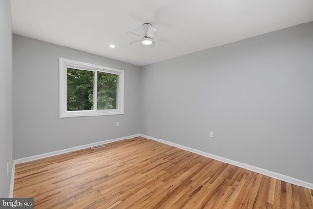 empty room with ceiling fan and light hardwood / wood-style floors