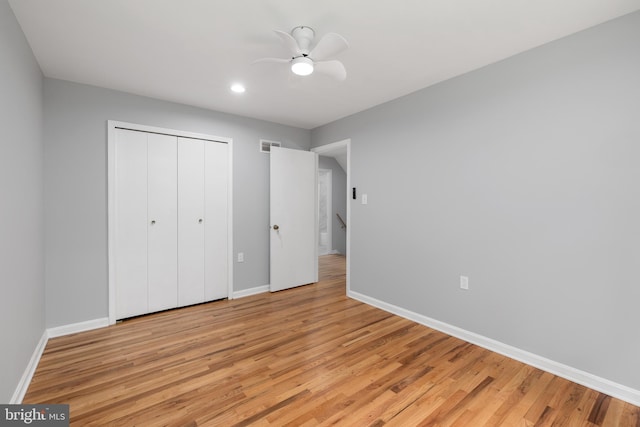 unfurnished bedroom featuring ceiling fan, light wood-type flooring, and a closet