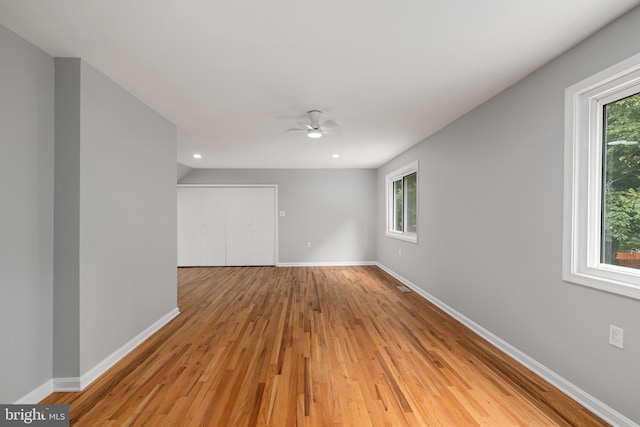 empty room with ceiling fan and light hardwood / wood-style floors