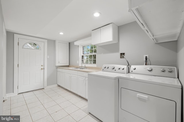 laundry area featuring cabinets, sink, light tile patterned floors, and washing machine and dryer