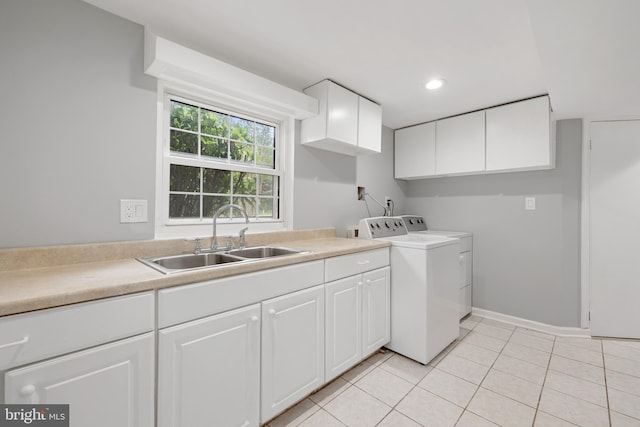 laundry area featuring light tile patterned flooring, sink, washing machine and clothes dryer, and cabinets