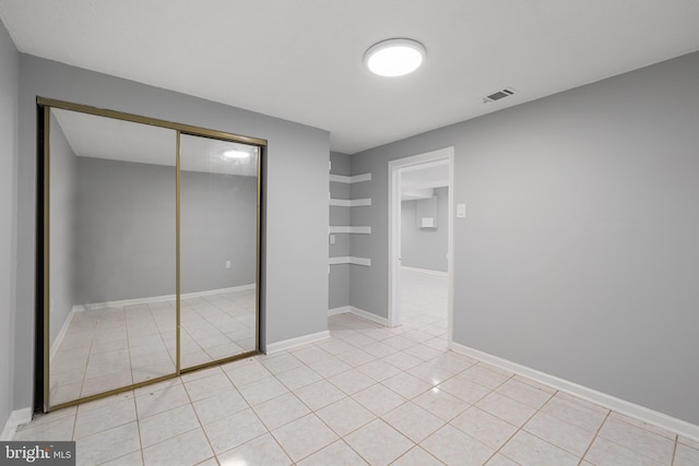 unfurnished bedroom with light tile patterned floors and a closet