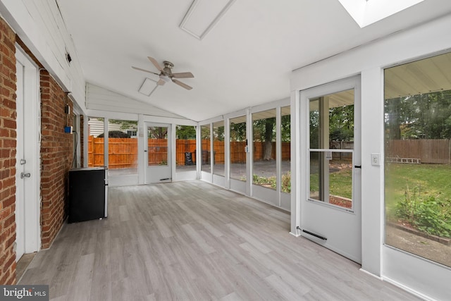 unfurnished sunroom with ceiling fan, vaulted ceiling, and a healthy amount of sunlight