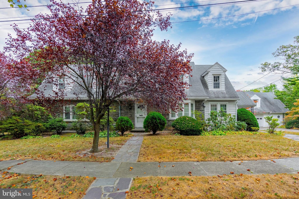 cape cod house with a front yard