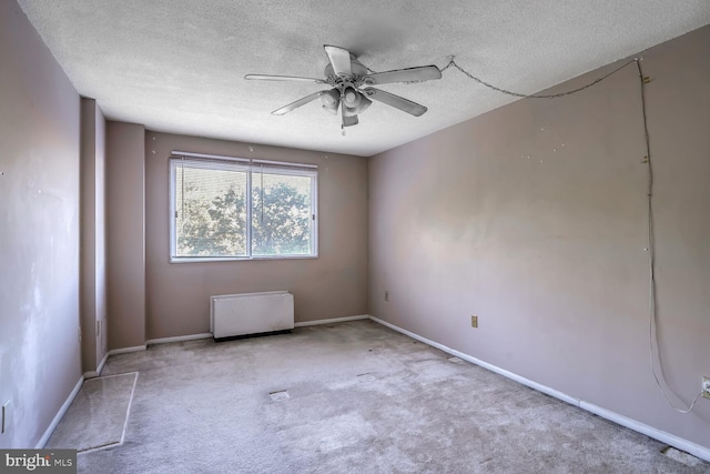 empty room with light carpet, a textured ceiling, and ceiling fan