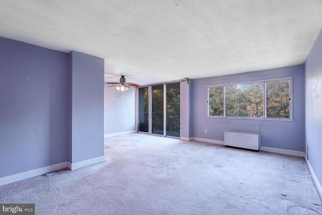 spare room with a textured ceiling and light colored carpet