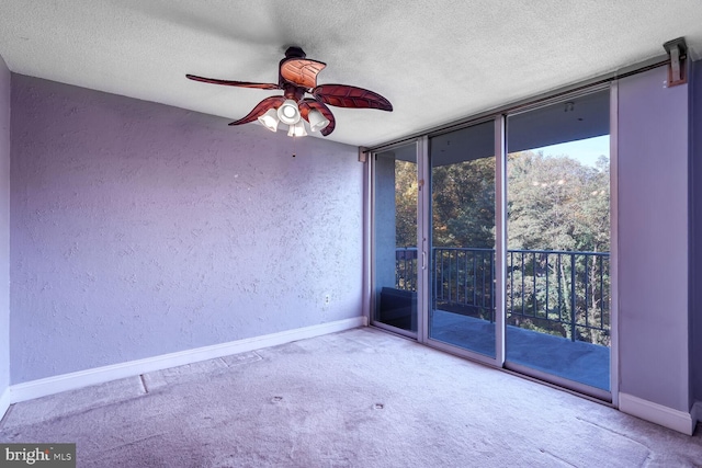 carpeted spare room featuring a textured ceiling and ceiling fan