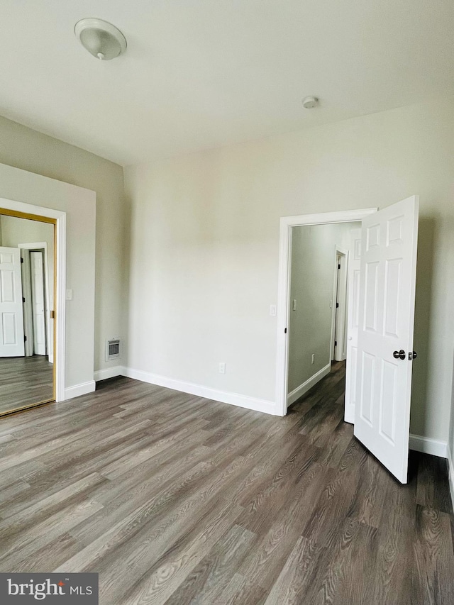 unfurnished room with dark hardwood / wood-style flooring